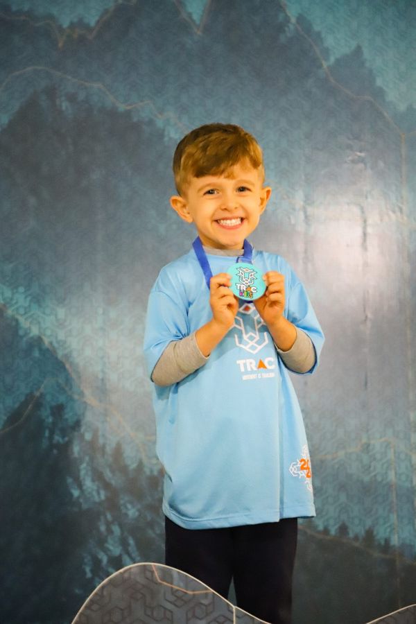 Criança com a medalha do TRAC Kids
